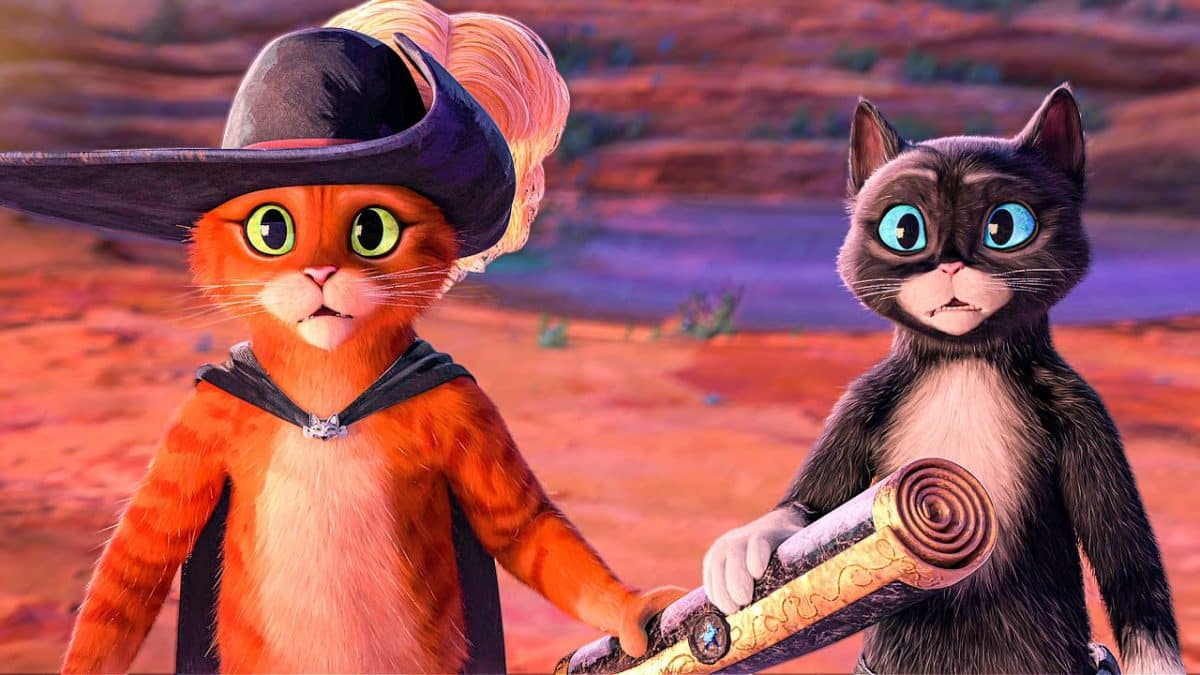 Two digitally animated cats stand in a desert holding a scroll.